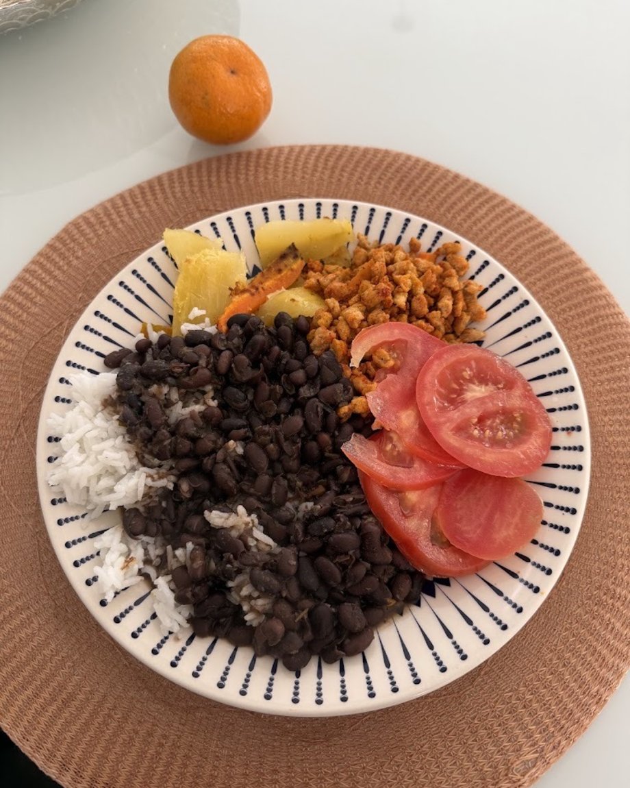 Prato com arroz, feijão preto, tomate, abóbora e proteína temperada